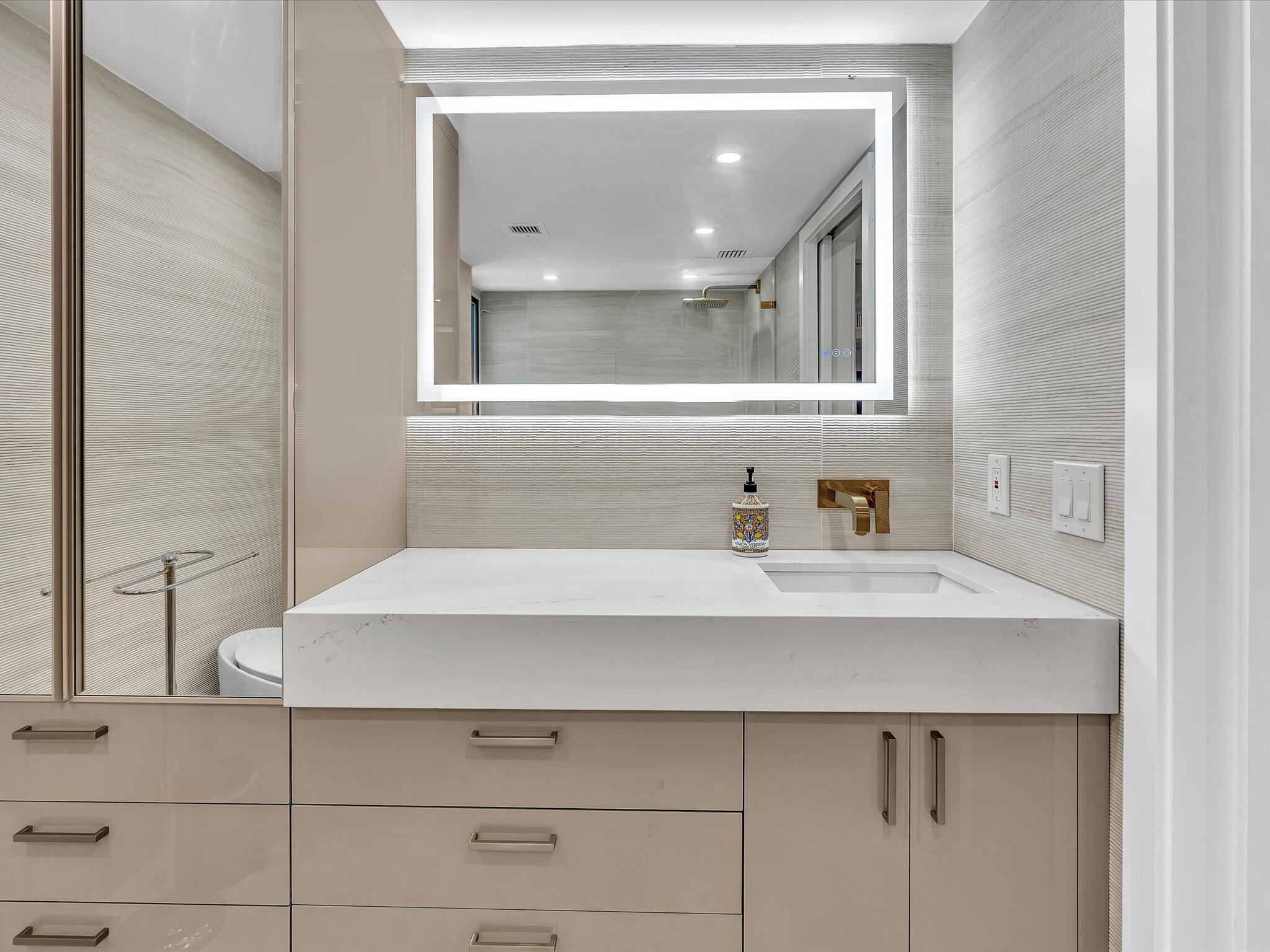 120 Southeast 5th Avenue, Unit 225 Boca Raton, FL 33432 - Photo 13 of 42 a bathroom with a sink and a mirror