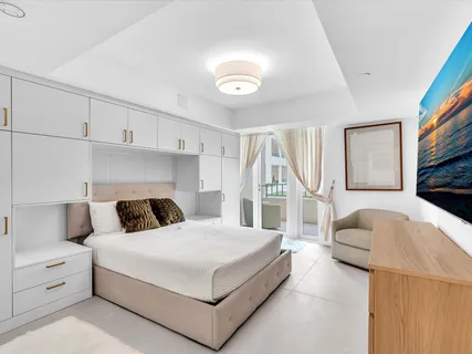 a bedroom with a white bed and a couch