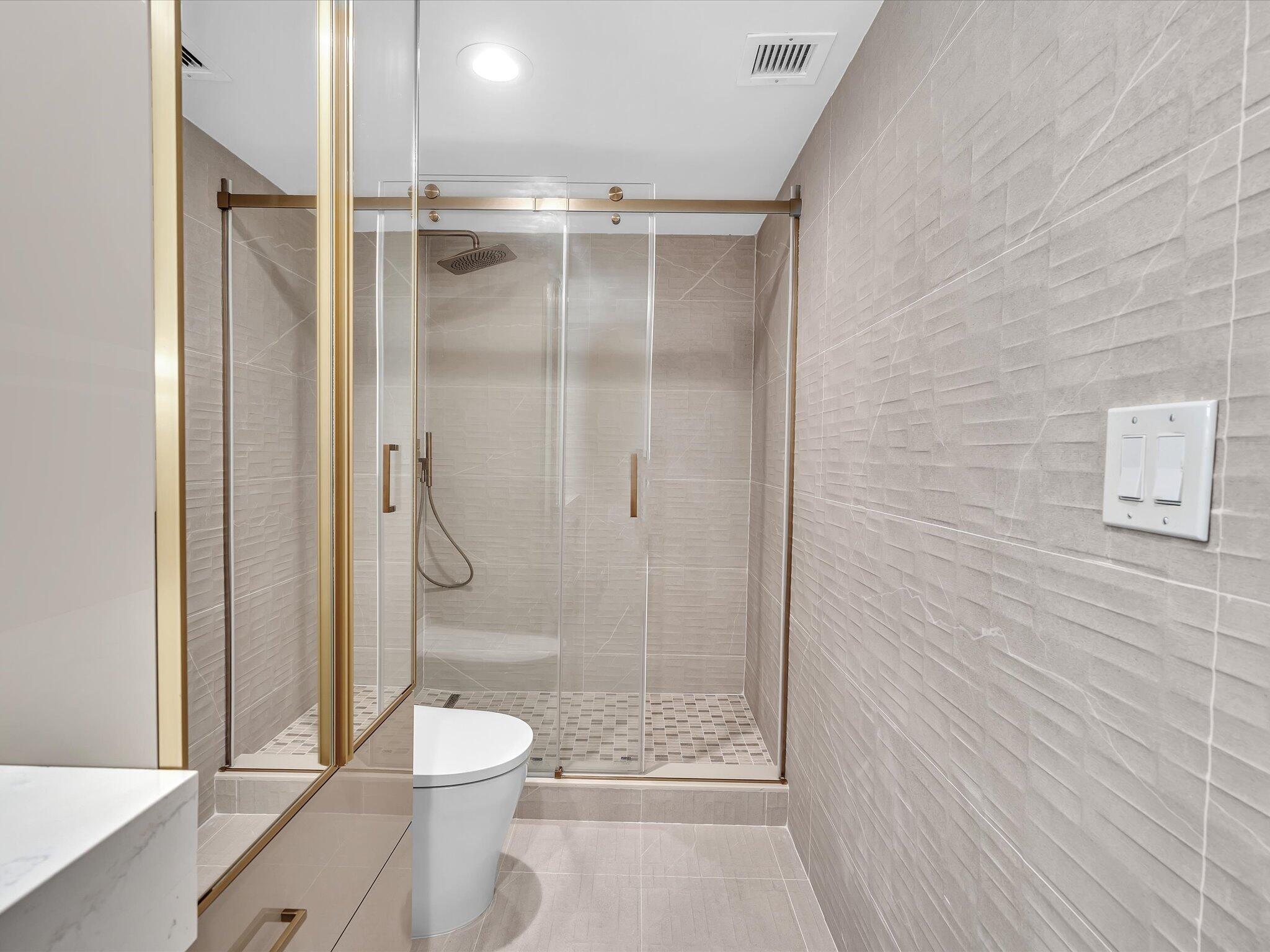 120 Southeast 5th Avenue, Unit 225 Boca Raton, FL 33432 - Photo 22 of 42 a bathroom with a shower a toilet and a shower