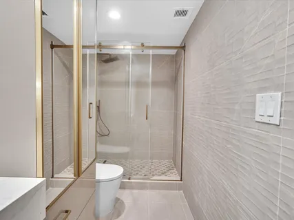 a bathroom with a shower a toilet and a shower