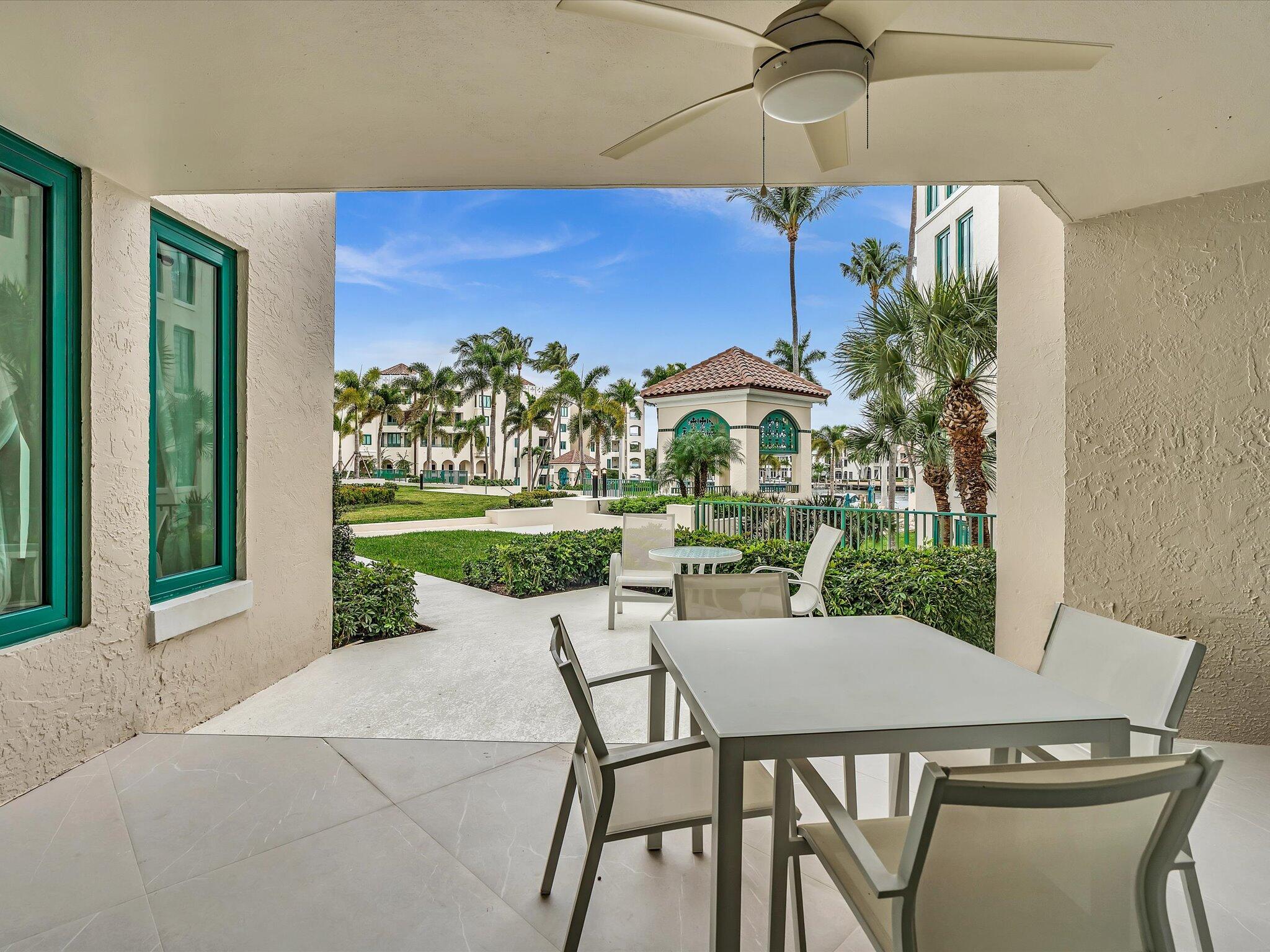 120 Southeast 5th Avenue, Unit 225 Boca Raton, FL 33432 - Photo 29 of 42 a patio with a table and chairs under an umbrella