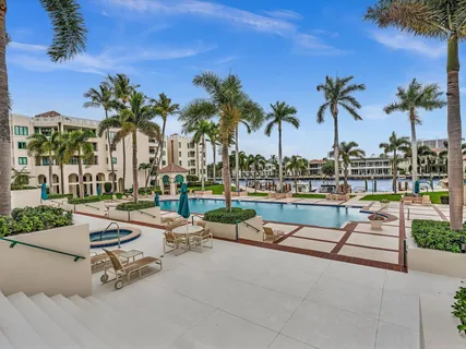 a row of palm trees and swimming pool in the backyard of a house