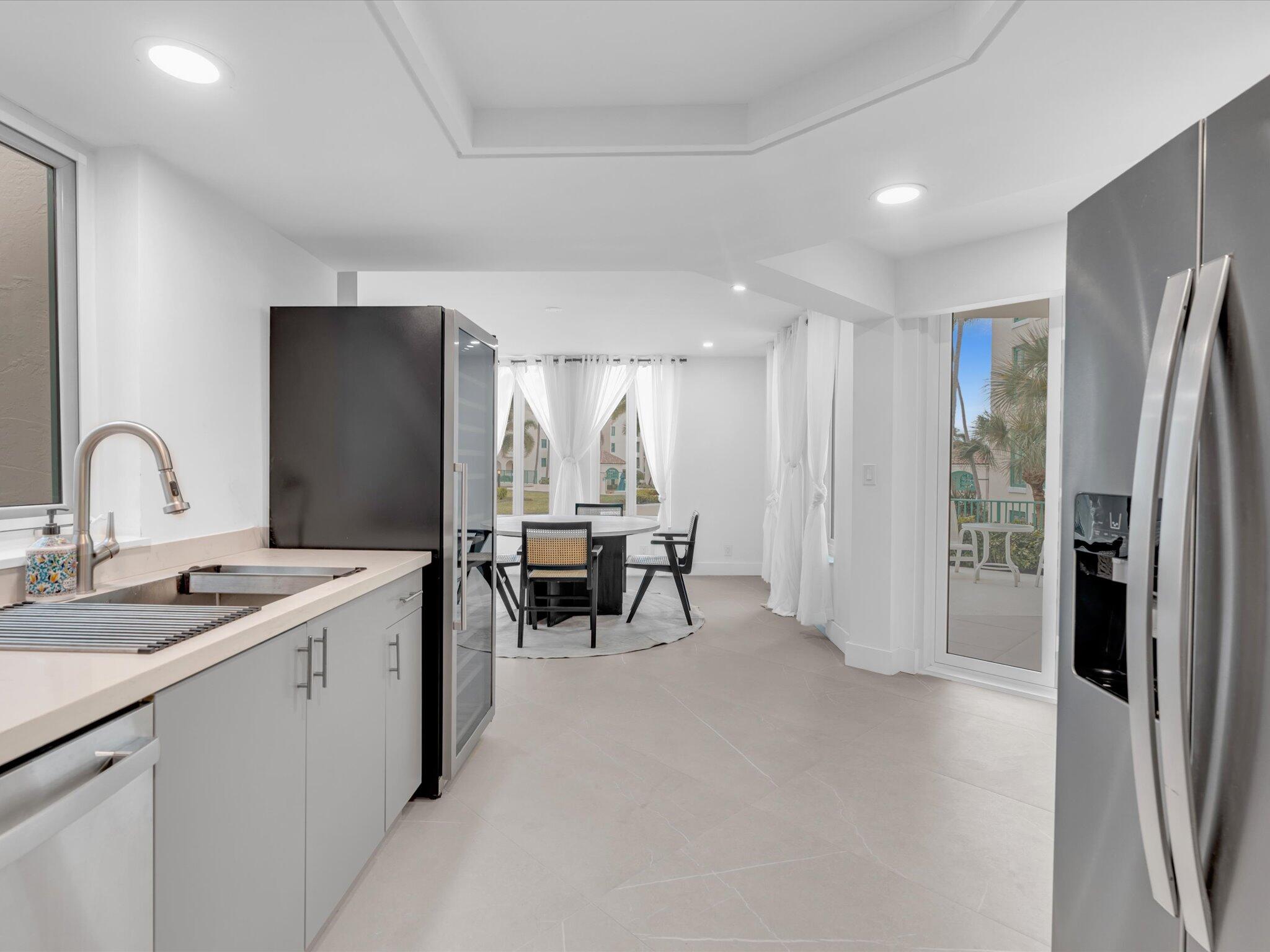 120 Southeast 5th Avenue, Unit 225 Boca Raton, FL 33432 - Photo 8 of 42 a kitchen with refrigerator and chairs