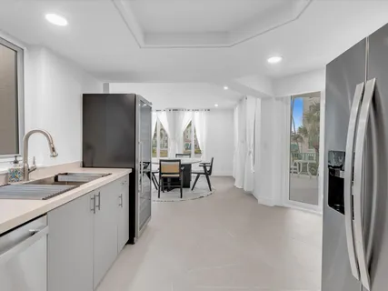 a kitchen with refrigerator and chairs