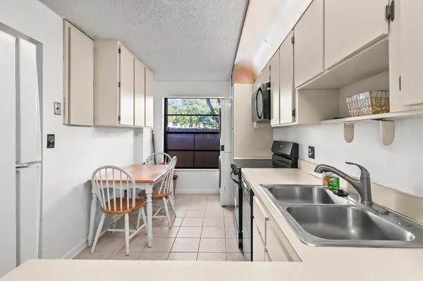 a kitchen with stainless steel appliances granite countertop a sink and a white cabinets