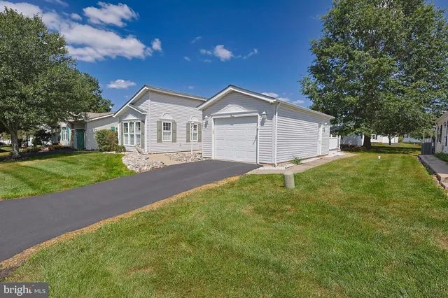 a front view of a house with a garden and yard