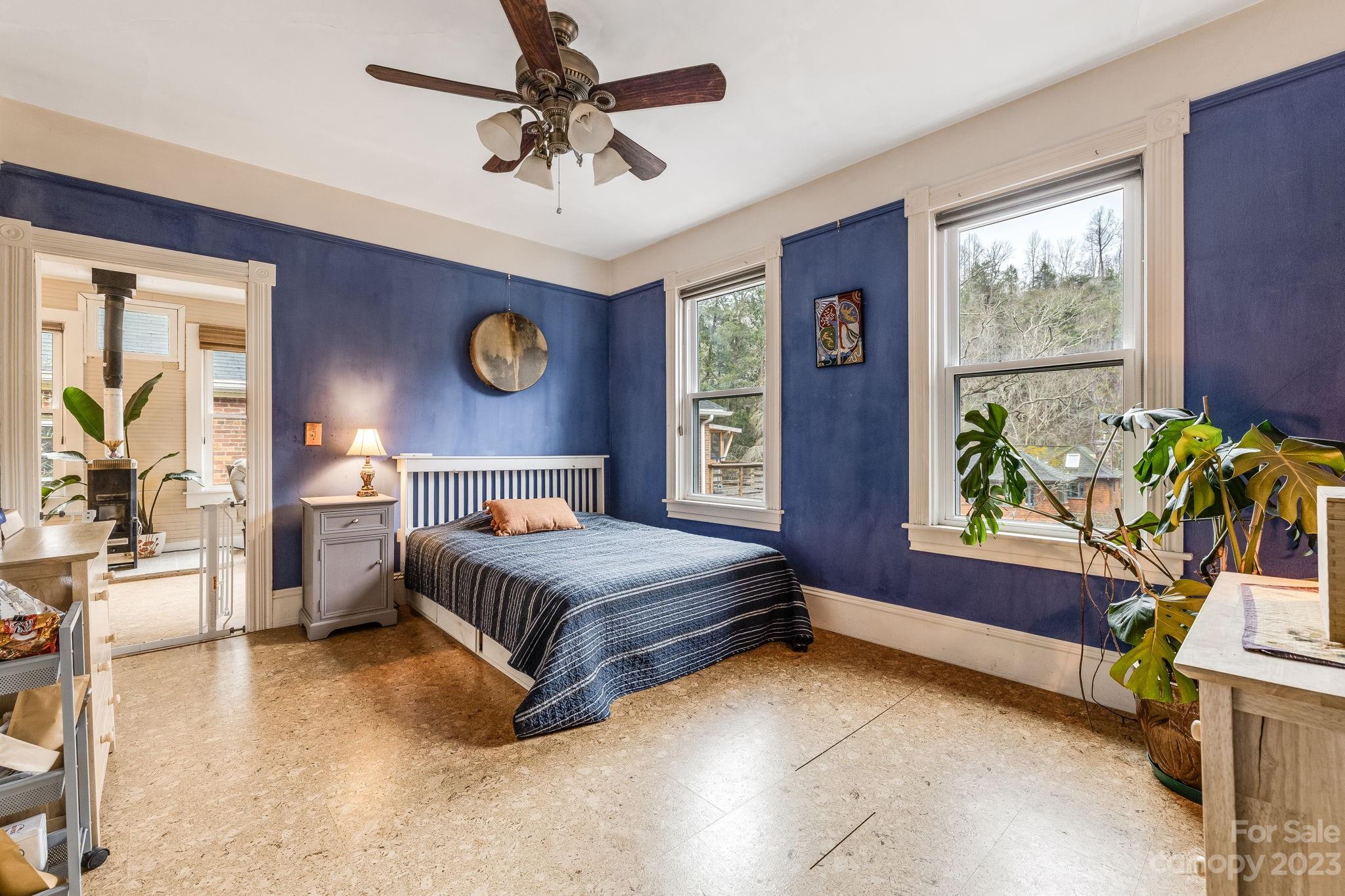 2412 Stackhouse Road Marshall, NC 28753 - Photo 28 of 48 a spacious bedroom with a bed and a chandelier