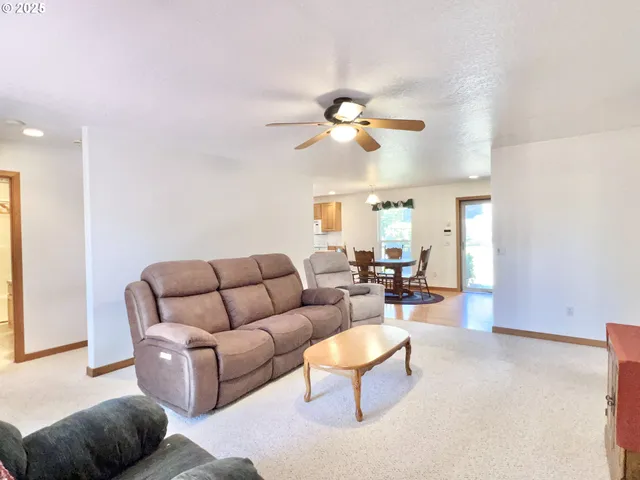 a living room with furniture a ceiling fan and a window