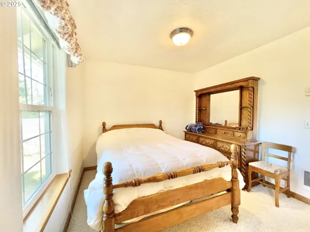 a bed sitting in a bedroom next to a window