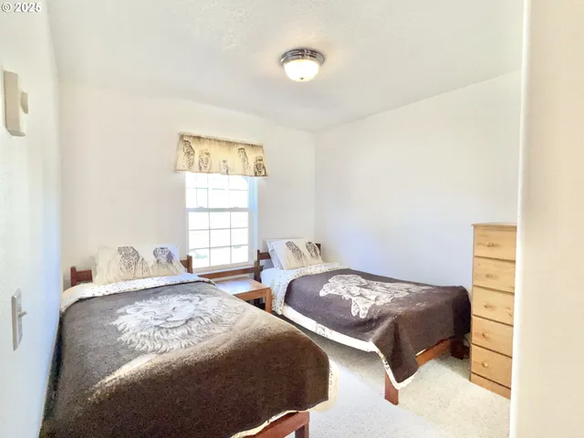 a bedroom with two beds and a window