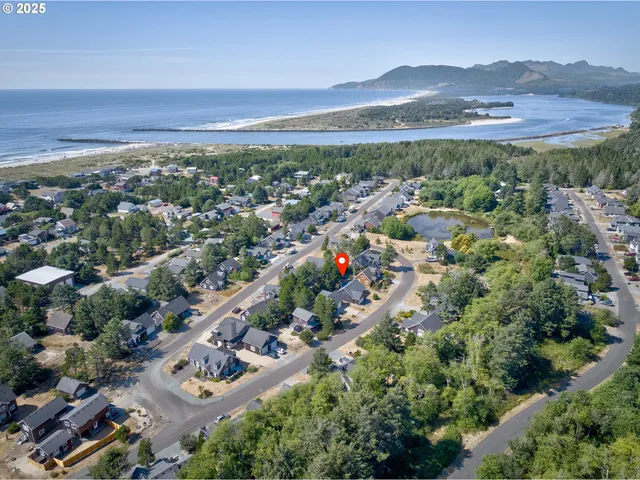 an aerial view of a city with lots of residential buildings ocean and mountain view in back