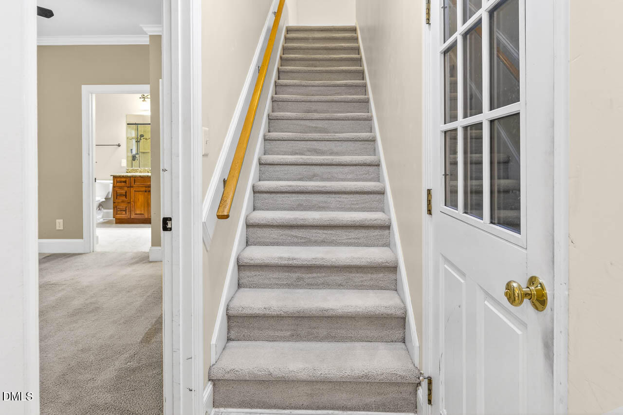 2209 Lodestar Drive Raleigh, NC 27615 - Photo 44 of 50 a view of staircase with white walls and windows
