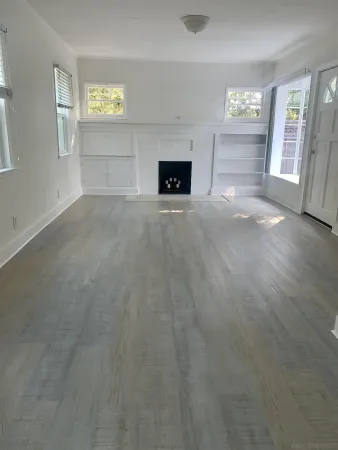 an empty room with windows and cabinet