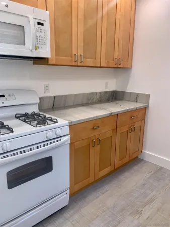 a kitchen with granite countertop cabinets and white appliances