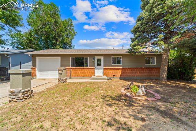 1663 Maxwell Street Colorado Springs, CO 80906 - Photo 2 of 23 Ranch-style house featuring a garage, brick siding, and driveway