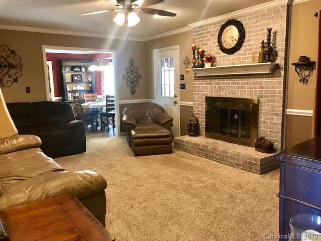 2802 Reece Drive Monroe, NC 28110 - Photo 9 of 37 a living room with furniture a clock and a fireplace