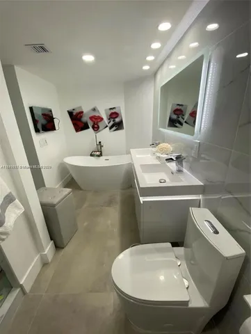 a bathroom with a sink and mirror with toilet
