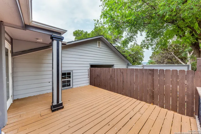 a view of backyard with wooden floor and fence