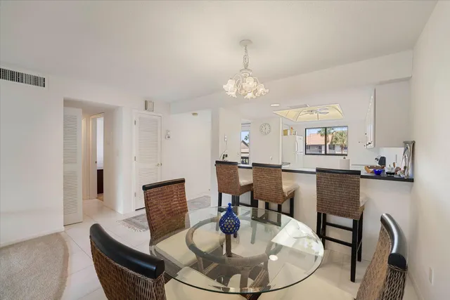 a living room with furniture a dining table and a chandelier