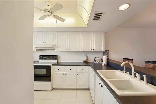 a kitchen with white cabinets appliances and a sink