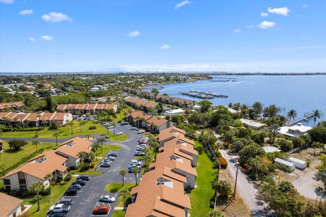 an aerial view of a city with lots of residential buildings and ocean view in back