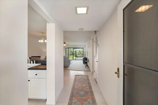 a view of a hallway with a livingroom and a bathroom with sink