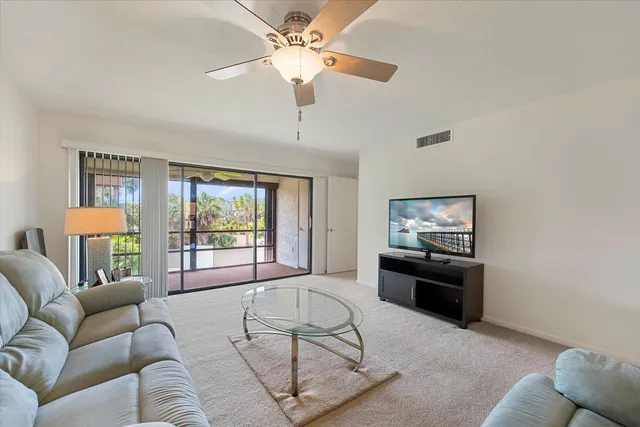 a living room with furniture a large window and a flat screen tv