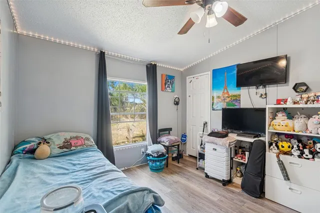 a bedroom with bed and a flat tv screen