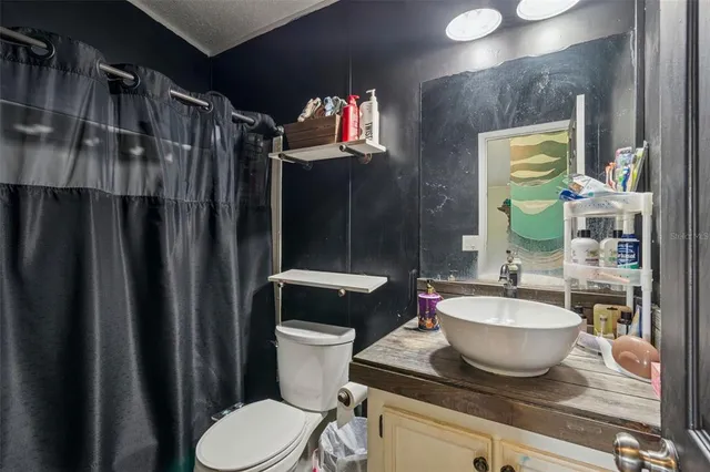 a bathroom with a granite countertop toilet sink and mirror