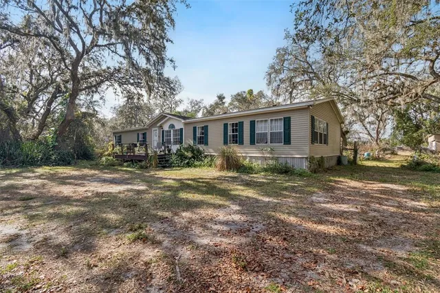 a front view of a house with a yard and trees