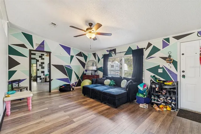 a living room with furniture and a wooden floor