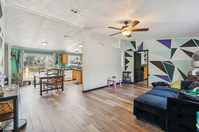 a living room with furniture a wooden floor and a chandelier
