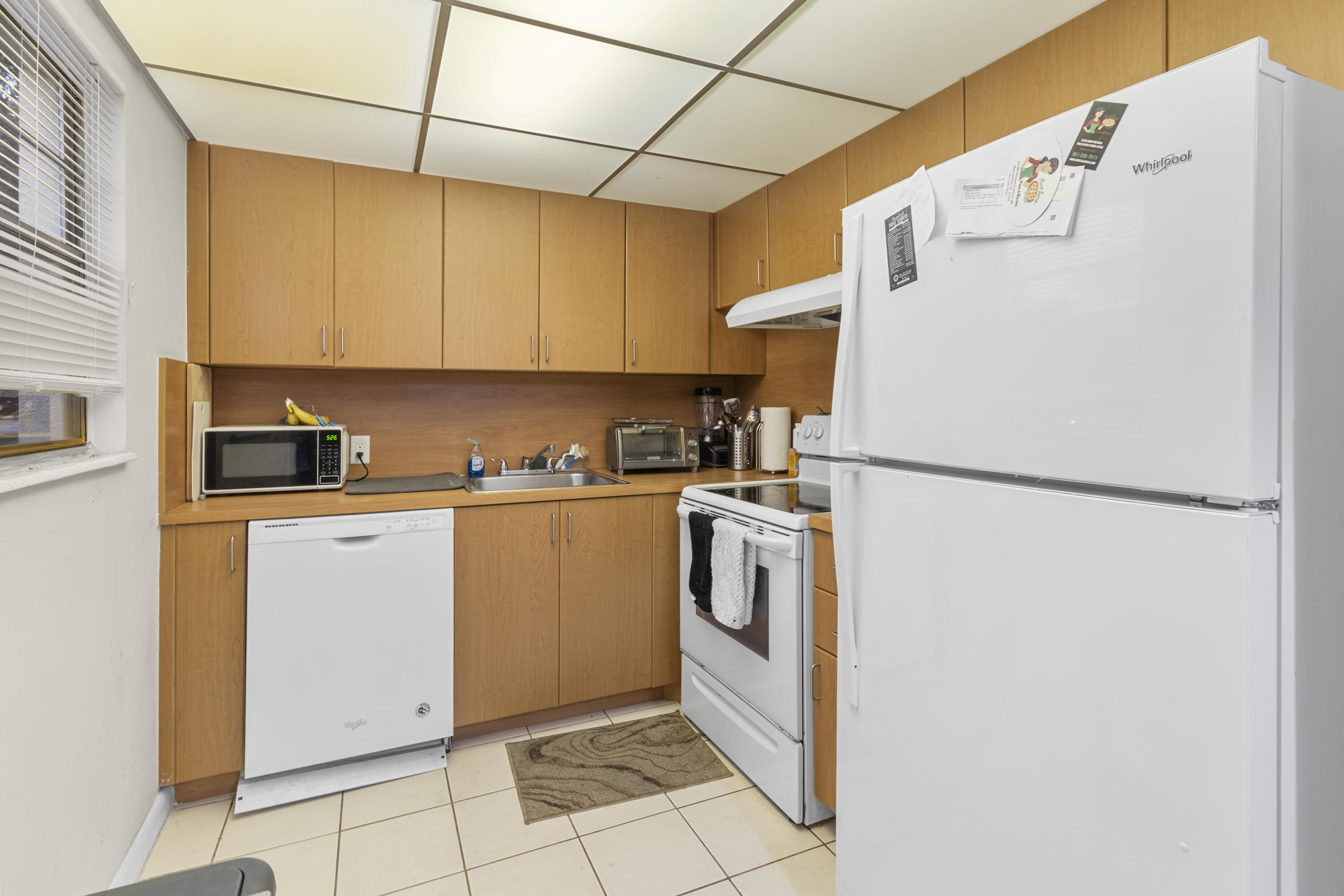 505 Mansfield M Boca Raton, FL 33434 - Photo 5 of 7 a kitchen with a refrigerator a stove top oven and cabinets