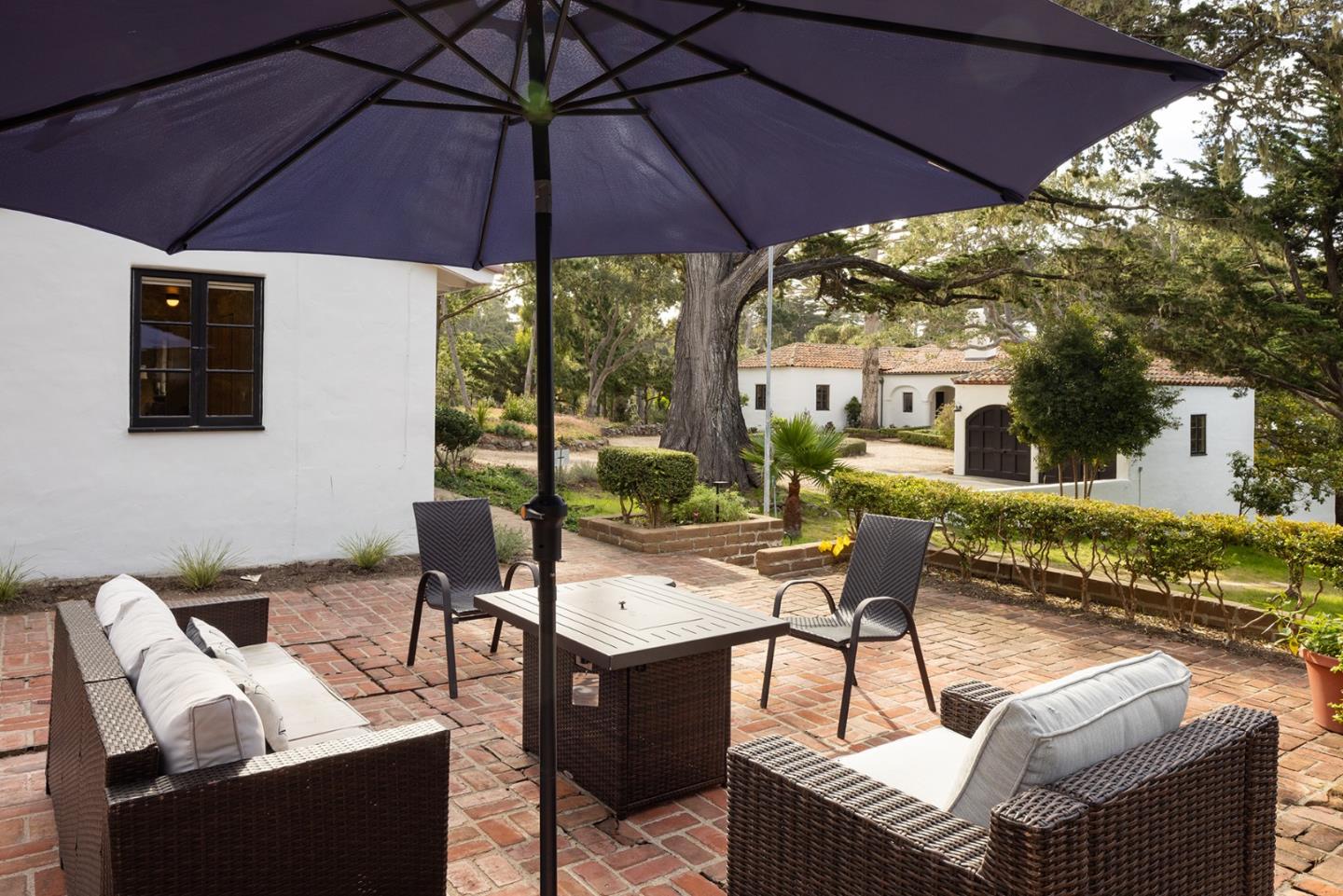 3269 Cabrillo Road Pebble Beach, CA 93953 - Photo 44 of 44 a view of a patio with couches table and chairs under an umbrella