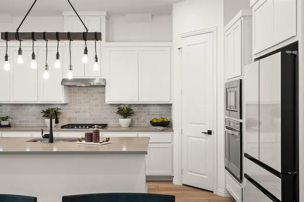 a kitchen with stainless steel appliances white cabinets and a refrigerator