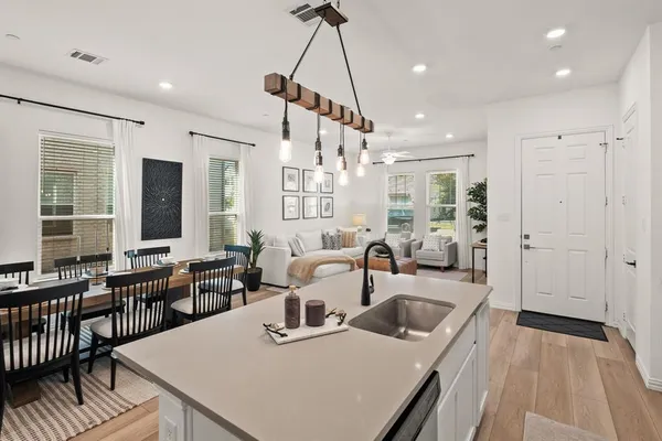 a view of a dining room and livingroom with furniture wooden floor a chandelier