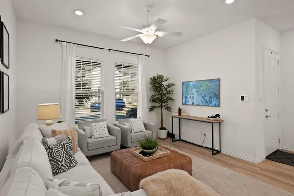 a living room with furniture ceiling fan and a window