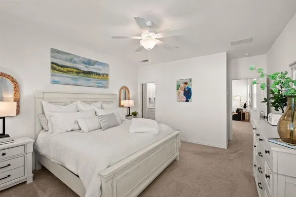 a bedroom with a bed a rug and a chandelier
