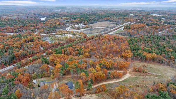 an aerial view of residential houses with outdoor space and trees