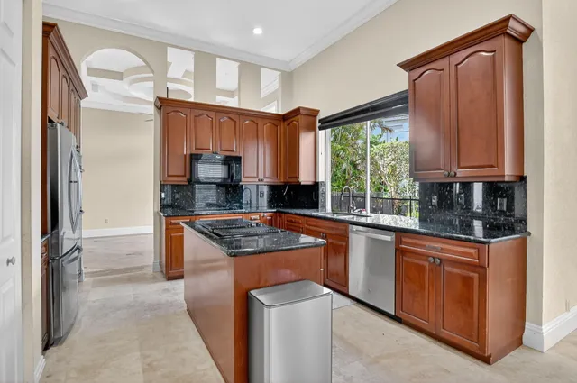 a kitchen with stainless steel appliances granite countertop a stove a sink and a refrigerator
