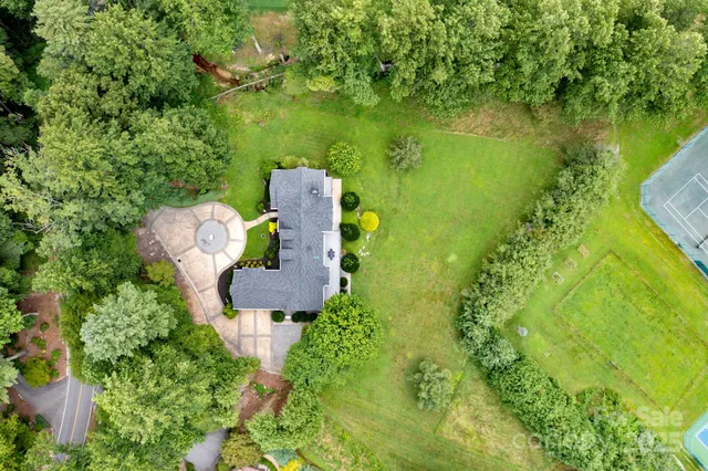 an aerial view of a house with a yard lake swimming pool and outdoor seating
