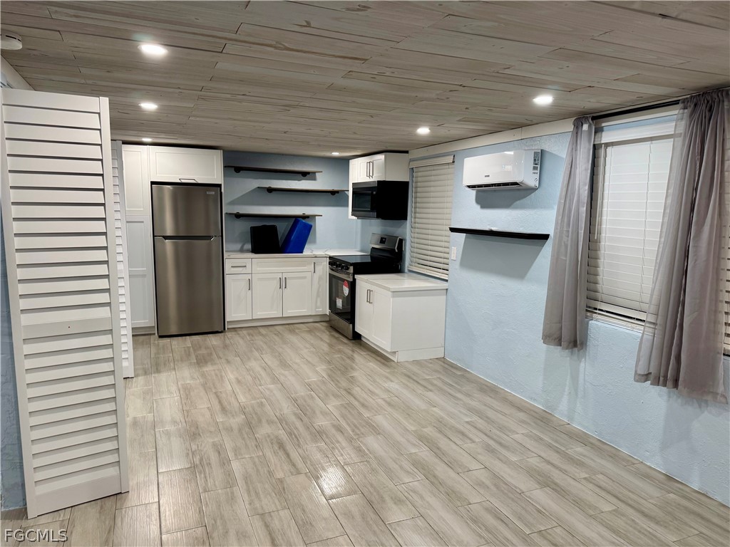 a living room with stainless steel appliances furniture a refrigerator and a kitchen stove