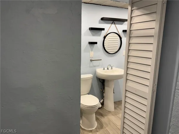 a bathroom with a toilet a sink and a mirror