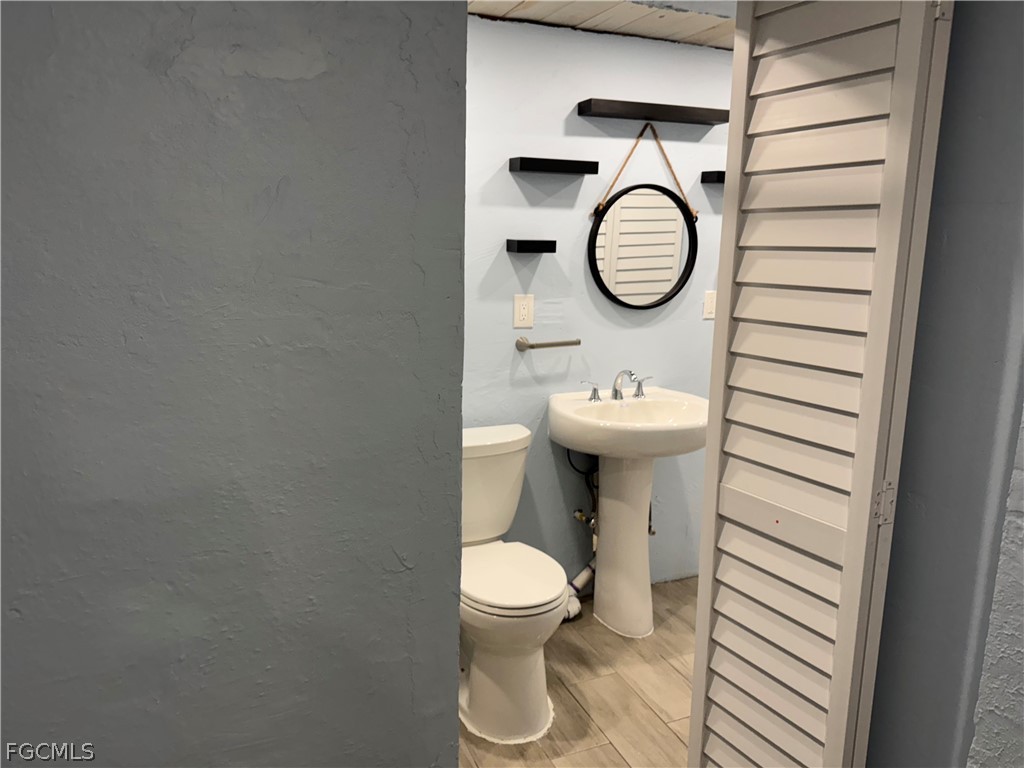 2566 Second Street, Unit A Matlacha, FL 33993 - Photo 4 of 8 a bathroom with a toilet a sink and a mirror