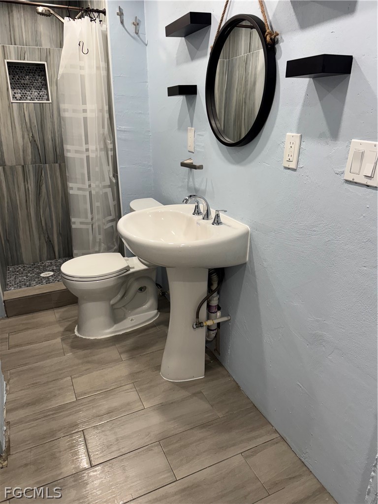 2566 Second Street, Unit A Matlacha, FL 33993 - Photo 6 of 8 a bathroom with a sink toilet and mirror