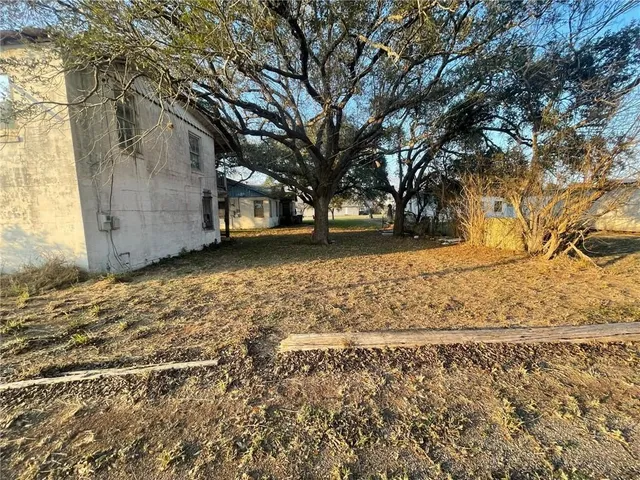 a view of a yard with wooden fence