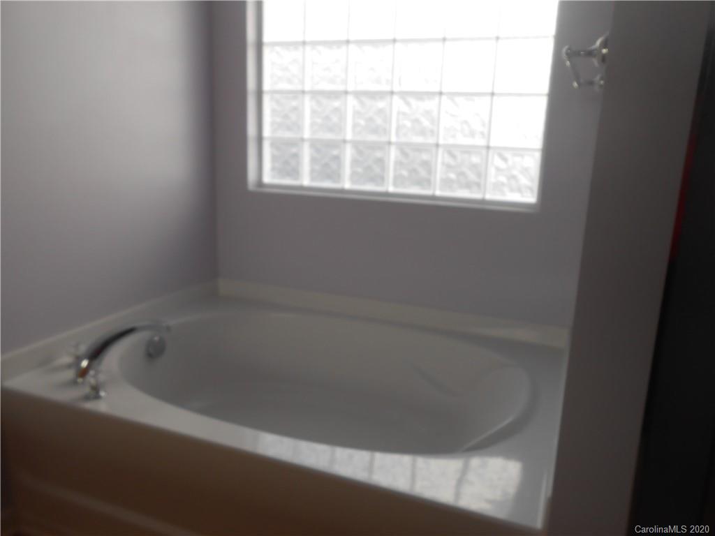 11605 Downy Birch Road Charlotte, NC 28227 - Photo 17 of 21 a white bath tub sitting next to a window