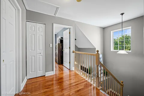 a view of a hallway with wooden floor and entryway
