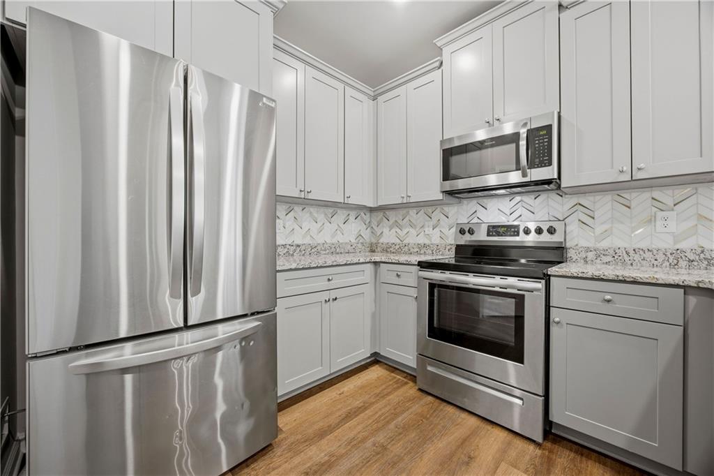 70 Gold Mine Road Grantville, GA 30220 - Photo 8 of 23 a kitchen with stainless steel appliances white cabinets a sink and a stove