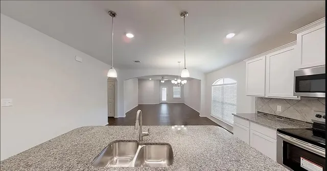 a large kitchen with kitchen island a sink stainless steel appliances and cabinets